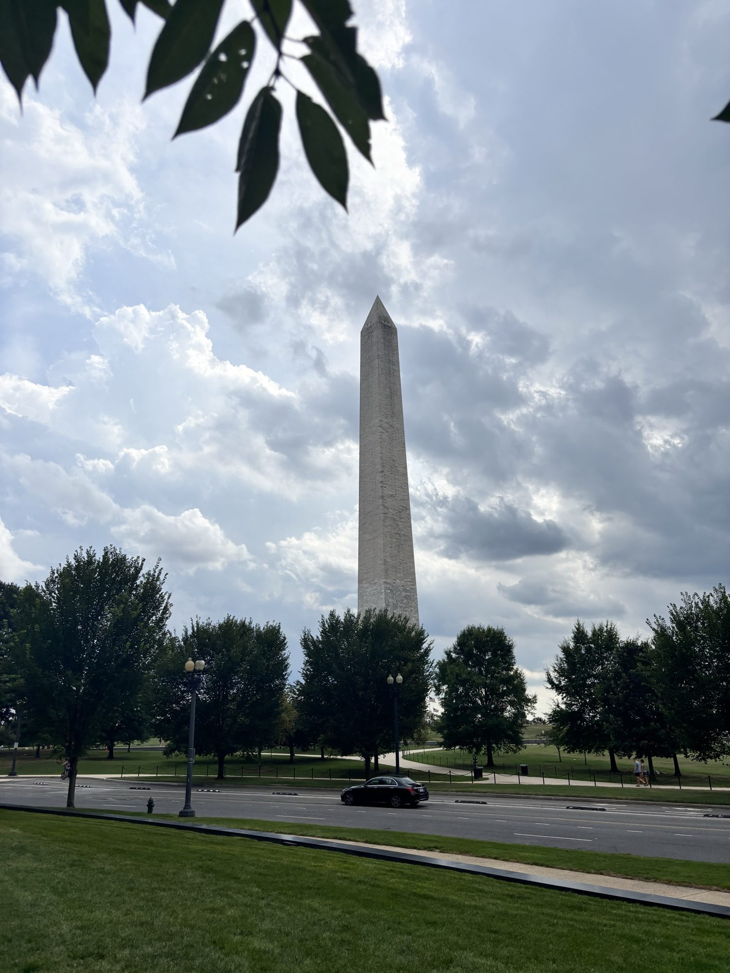 Washington Monument framed by leaves and clouds