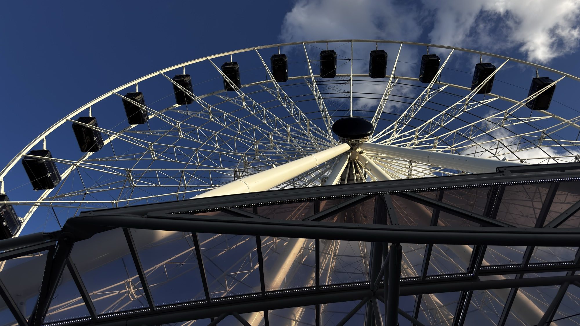Looking up at a Ferris wheel against a blue sky