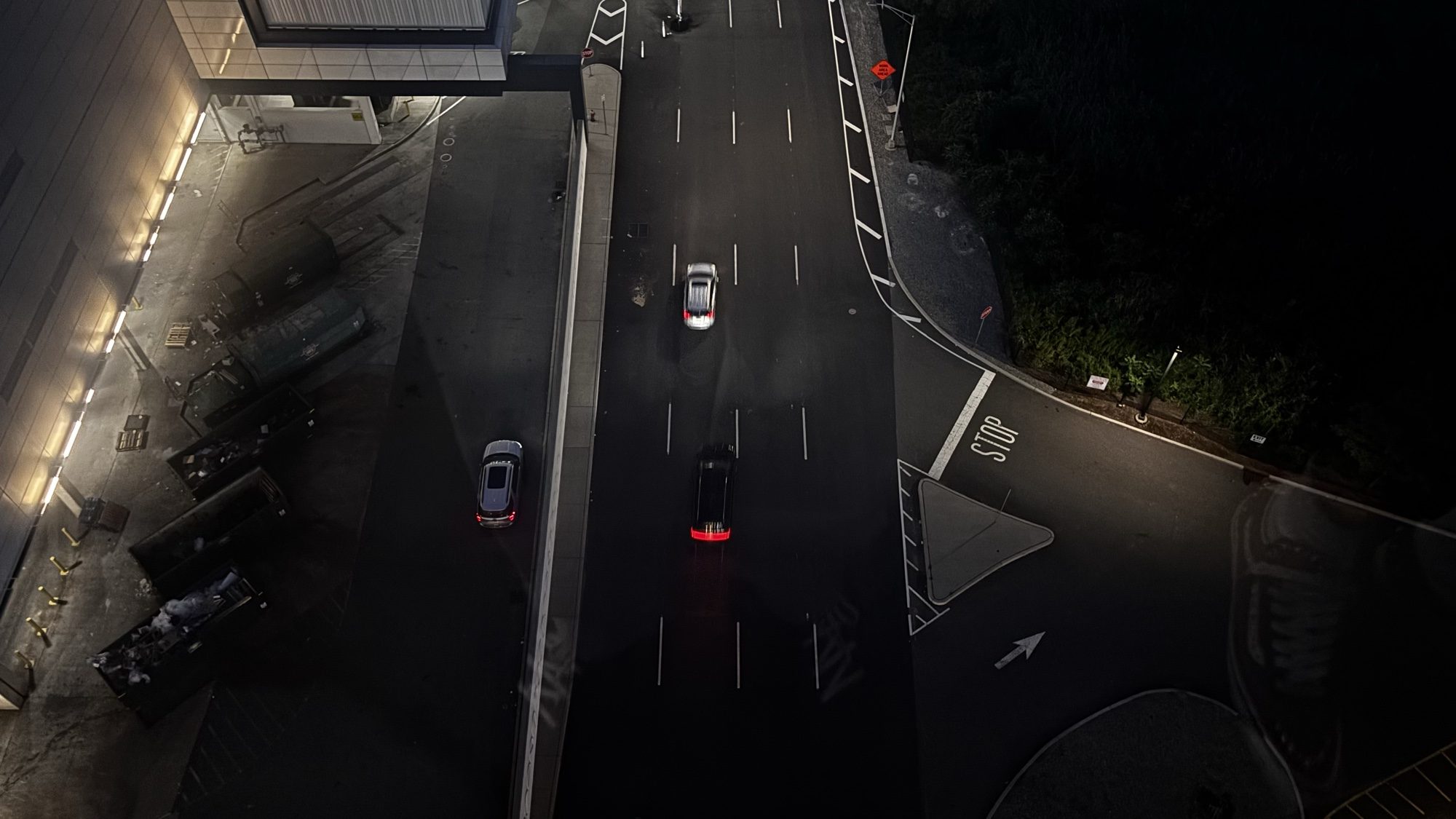 Looking down on a lit road and parking area at night