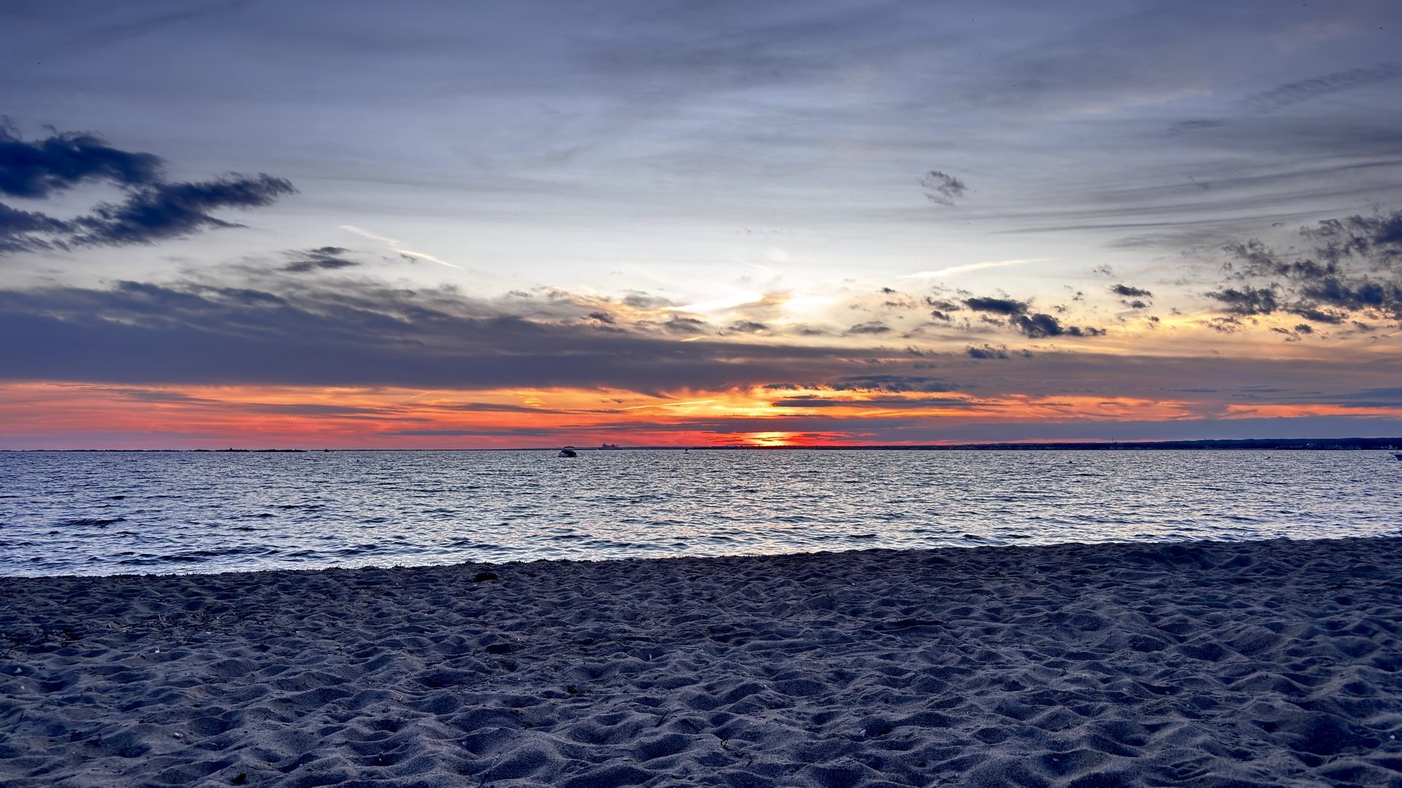 Sunset over the ocean, seen from a sandy beach